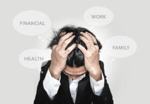 Image of a man holding his head surrounded by word bubble show the areas he needs help in order to cope with stress. There are many different stress management tools that could be used for the areas that are bother him (i.e. work, health, financial, and family). One of the biggest tools is therapy for stress in San Diego, CA.