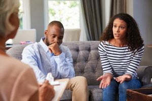 Image of a couple speaking with a couples therapist and marriage counselor in San Diego. Showing how you can talk through issues in trauma therapy and marriage counseling.