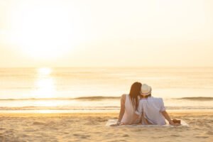 Image of a couple sitting happily together on a beach. If this is your goal them a Marriage counselor in San Diego can help. Through couples therapy and marriage counseling you can get to this point of happiness.