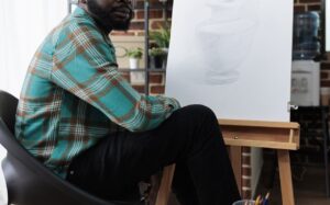 Image of a black man drawing which can be a hobby used to reduce stress. Taking time for hobbies can be an important part of stress management. However when that isn't enough therapy for stress in San Diego can give you the tools that you need.