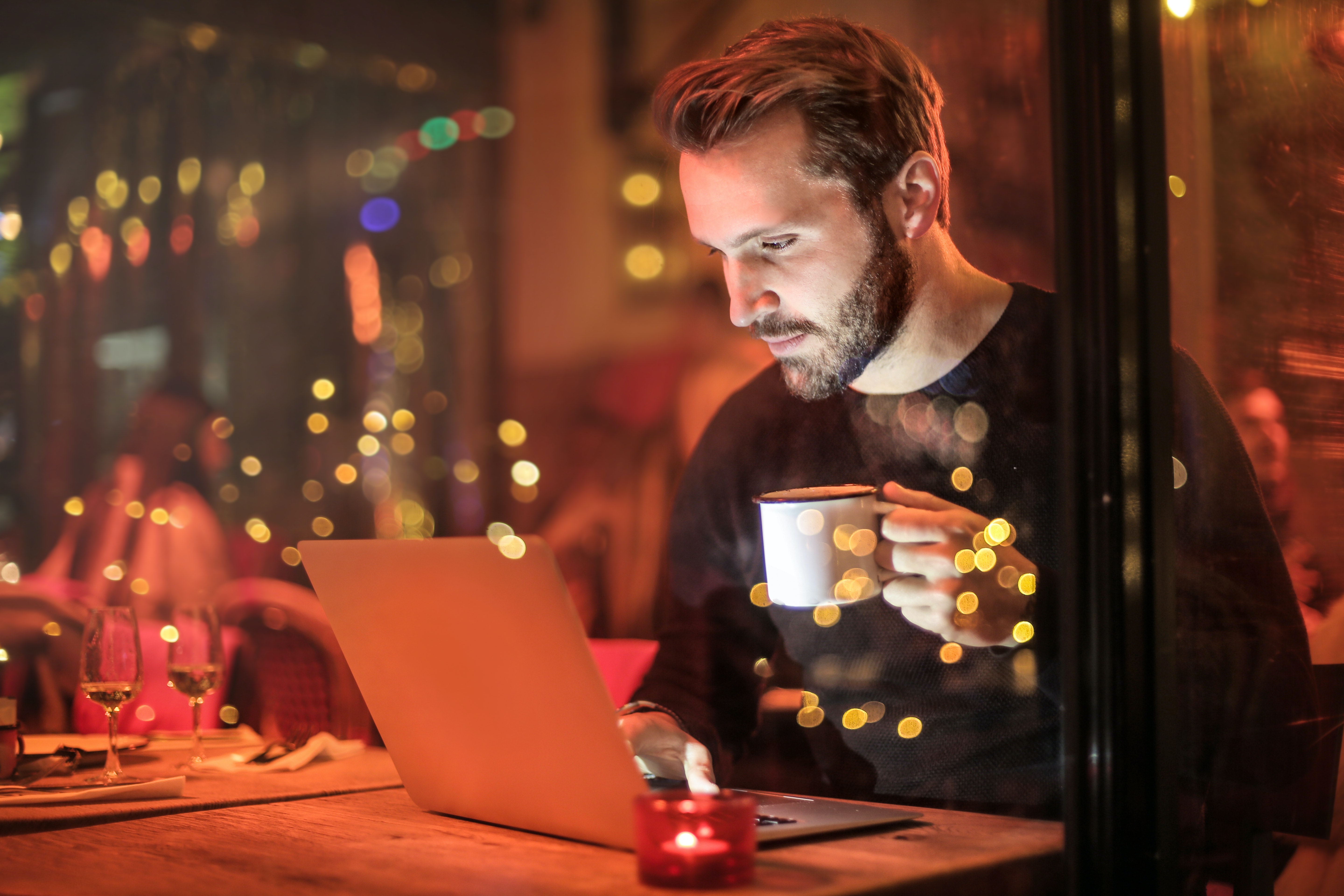 Image of a man holding a cup of coffee while sitting at a laptop in a diner. One of the ways you can reduce stress is by finding a work-life balance. By doing this to help cope with stress you wont feel the Sunday night anxiety. If this is a struggle for you then therapy for stress management in San Diego can help.