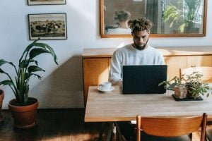 Image of a man working from home in his kitchen. Representing how online therapy for men in Portland, Oregon can make it easier to set work boundaries. With help from an online therapist you can have a healthy work life balance.