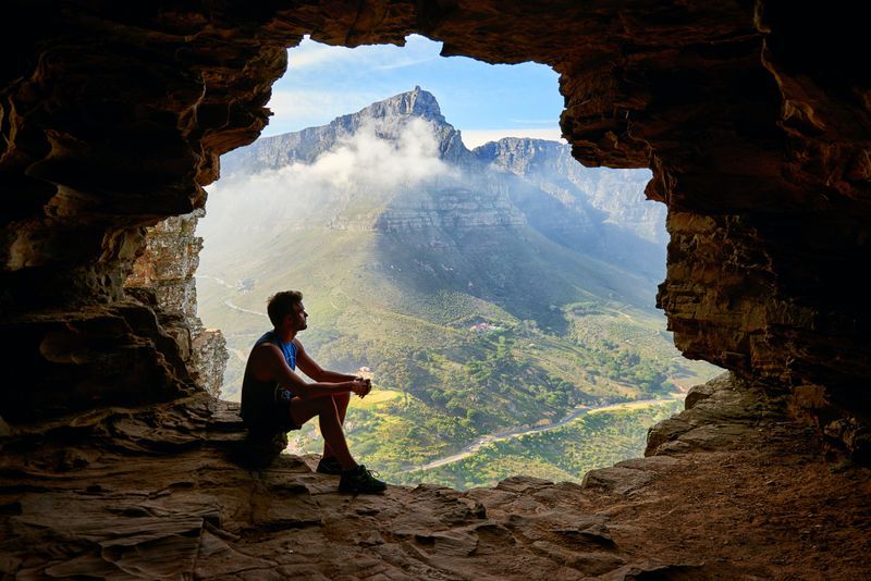 Image of a man sitting in a rocky cave looking at a beautiful landscape. Getting anxiety help is possible. I provide anxiety treatment in San Diego, CA. Call today to get rid of your anxiety symptoms and start living your best life in California. Call today to get started!