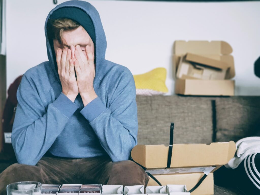 Image of a man in a blue hoodie covering his face. As a San Diego anxiety therapist I can provide you with anxiety help. After starting anxiety treatment in San Diego, CA you will start experiencing less anxiety symptoms. Reach out today to get started.