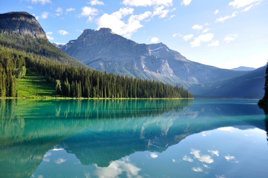 Image of a mountain behind a lake surrounded by trees which shows the peace and beauty that can come with addiction recovery in San Diego. Addiction treatment can lead you to a place of serenity when you are working with the right style of San Diego addictions counseling.