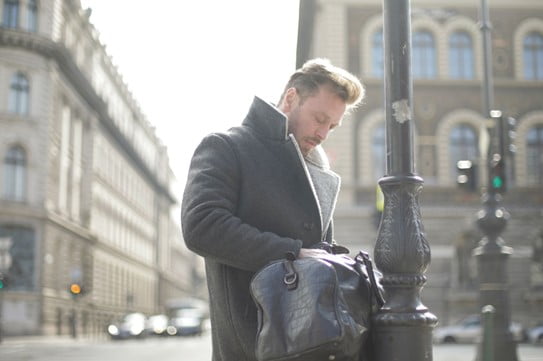 Image of a man in a black coat looking down and pensive. Representing someone who could benefit from EMDR therapy in San Diego, CA, Oregon, or Florida. You can feel better without reliving the memories with help from a San Diego EMDR therapist .