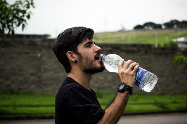 Image of a man drinking a bottle of water outside. Showing the positive effects of alcohol counseling in Portland, OR. An addictions counselor can help when you are ready to start healing from addiction in Portland, Oregon. 