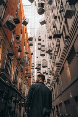 Image of a man walking along a street with things hanging about him. This represents how if you are feeling lost a San Diego EMDR therapist can help. Through EMDR in San Diego, California, Oregon, and Florida you can replace the negative emotions that are making you feel isolated and lost.