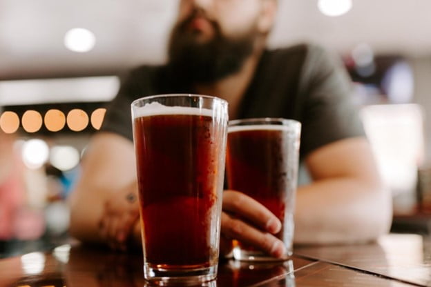 Image of two beers in front of a man. Showing what it can look like when you need support for healing from addiction in Portland, OR. You can get support from alcohol counseling and addictions counseling in San Diego, CA.