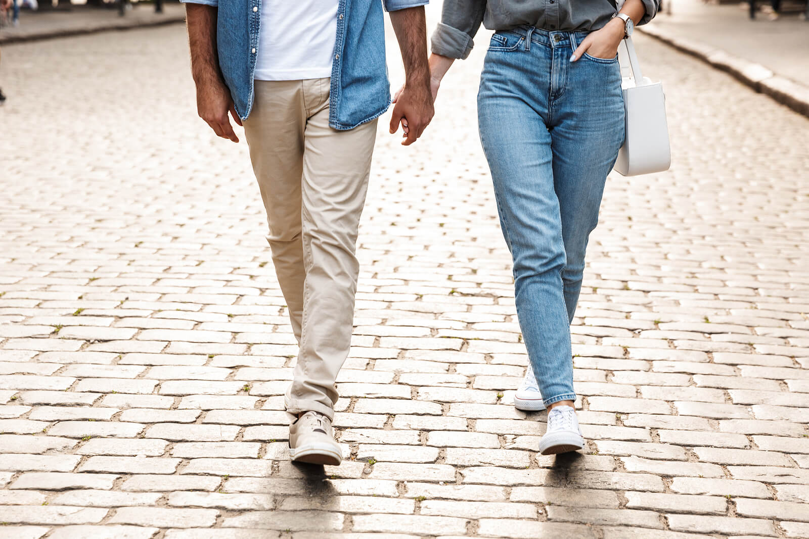 Image of a couple walking along a brick road. Representing a couple that went to couples therapy in San Diego and found the answer to "what is stonewalling". Who were then able to find techniques against stonewalling with support of a San Diego couples therapist.