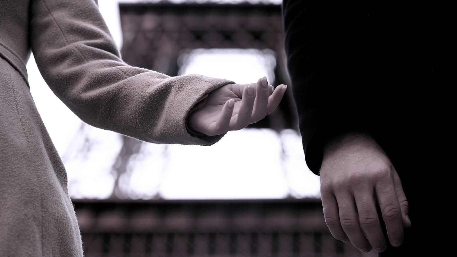 Black and white image of a man reaching out her hand to the man standing next to her. Representing a relationship that could benefit seeing a marriage counselor for online marriage counseling in San Diego,CA or Portland, OR.
