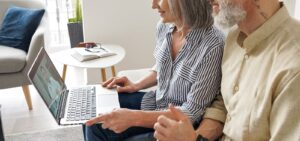 Image of an older couple meeting with a San Diego couples therapist on their laptop. Showing them putting in the working during online couples therapy or online marriage counseling in San Diego, California.