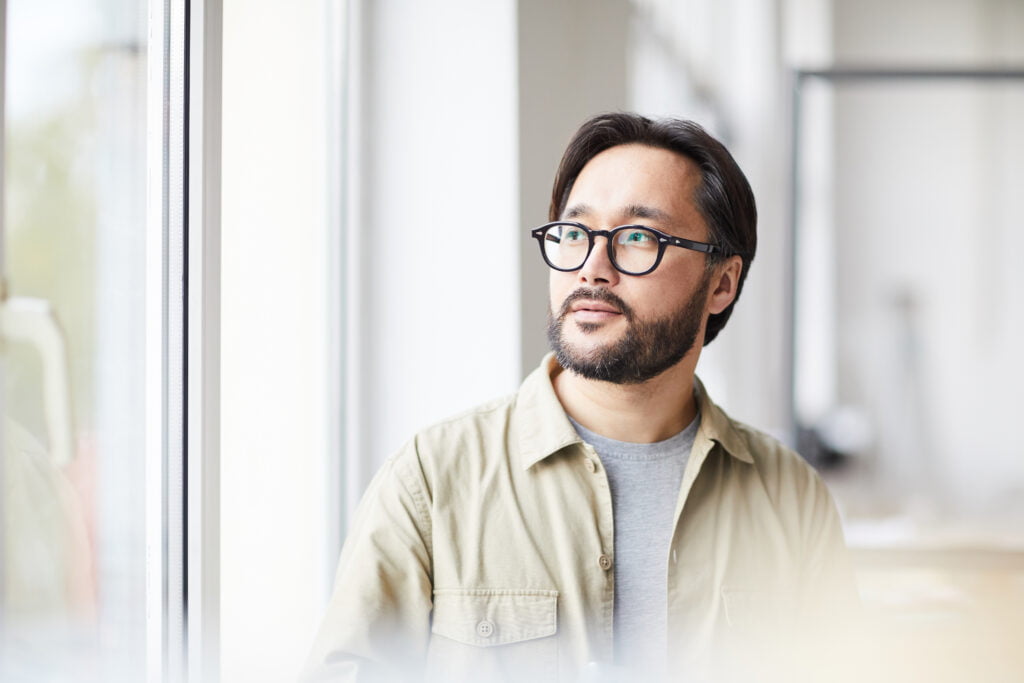 A man is staring out of the window to contemplate if he is dating the right person.