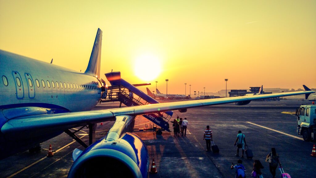 Image of passengers boarding an airplane outside during sunrise