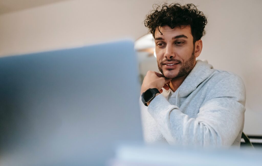 A close-up of a man talking to his laptop. Learn how to connect with an online therapist in California get reap the benefits of online therapy in Portland, OR today. 