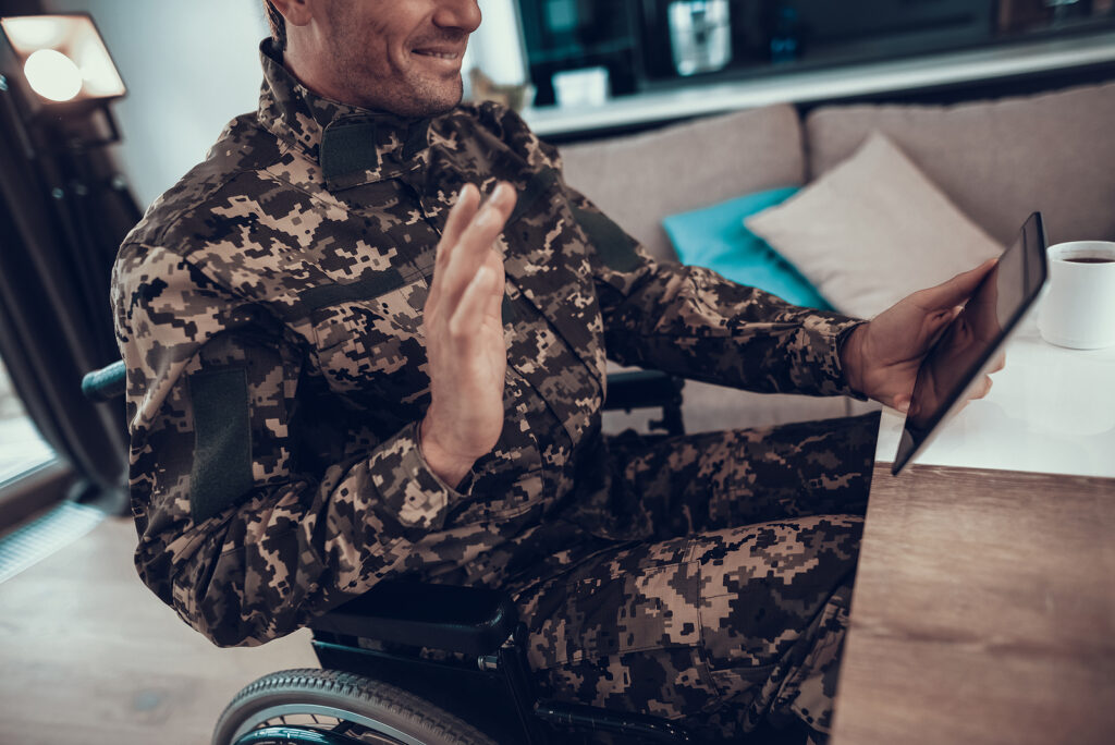 A man smiles while waving at his tablet, representing the support online therapy in Portland, OR can offer. Learn more about the help online therapy in California can offer today. 