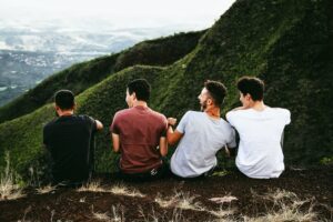 Four friends sit overlooking a mountian landscape. This could represent the support of friends when trying to cope with stress in San Diego, CA. Learn more about online therapy for men in Portland, OR and tips to reduce stress San Diego.
