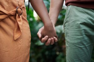 A close up of a couple holding hands. Learn how a San Diego couples therapist can help your relationship by searching for couples therapy in San Diego. They can tell you how online couples therapy in California can help today.