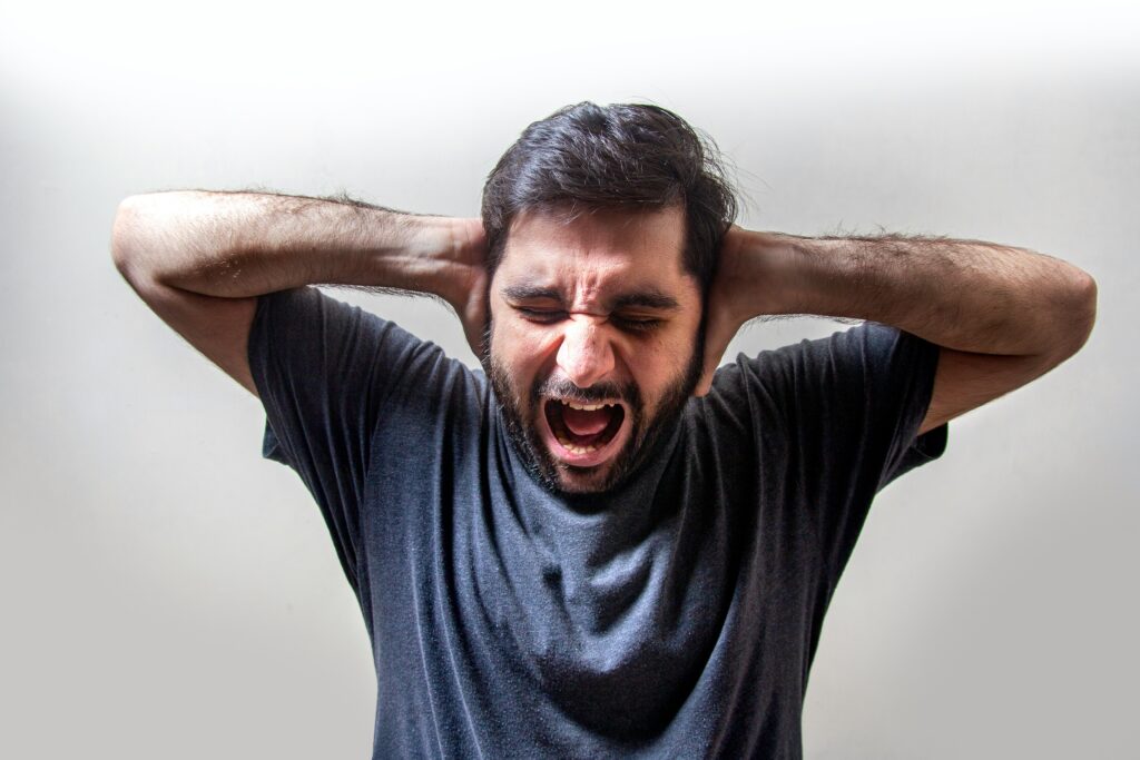 An image of a man screaming in distress because he has irrational fears that have controlled his life and needs to find peace through therapy for men in California