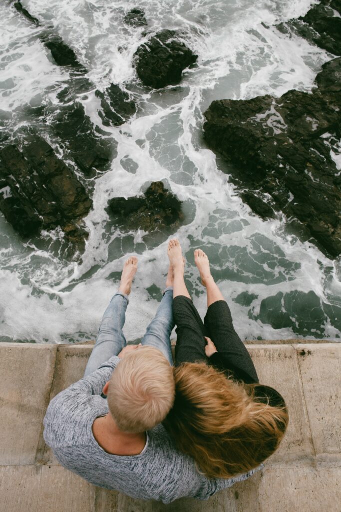 An image of a couple sitting on the edge of a dock over tumultuous water representing the feeling you can have when you are experiencing unsatisfying sex with your partner and do not know how to resolve the issue. Couples therapy in San Diego can help you find solutions to your relationship issues.