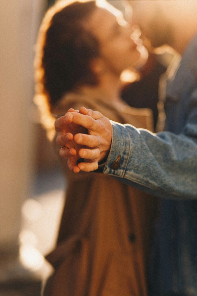 An image of a couple out of focus with their hands touching in focus symbolizing the intimacy that can be found after couples therapy in San Diego.