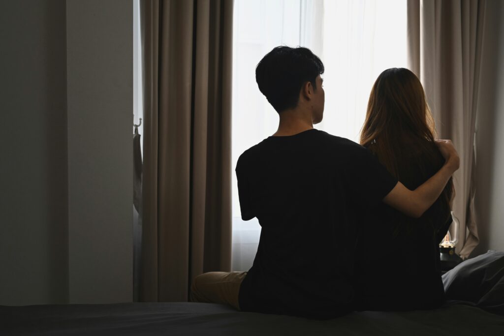 A couple sitting quietly together, depicting the emotional struggle and need for support during moments of relationship withdrawal.