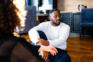 A man in a thoughtful moment during a therapy session, emphasizing the importance of anxiety therapy for men to work through challenges like anxiety and emotional suppression.