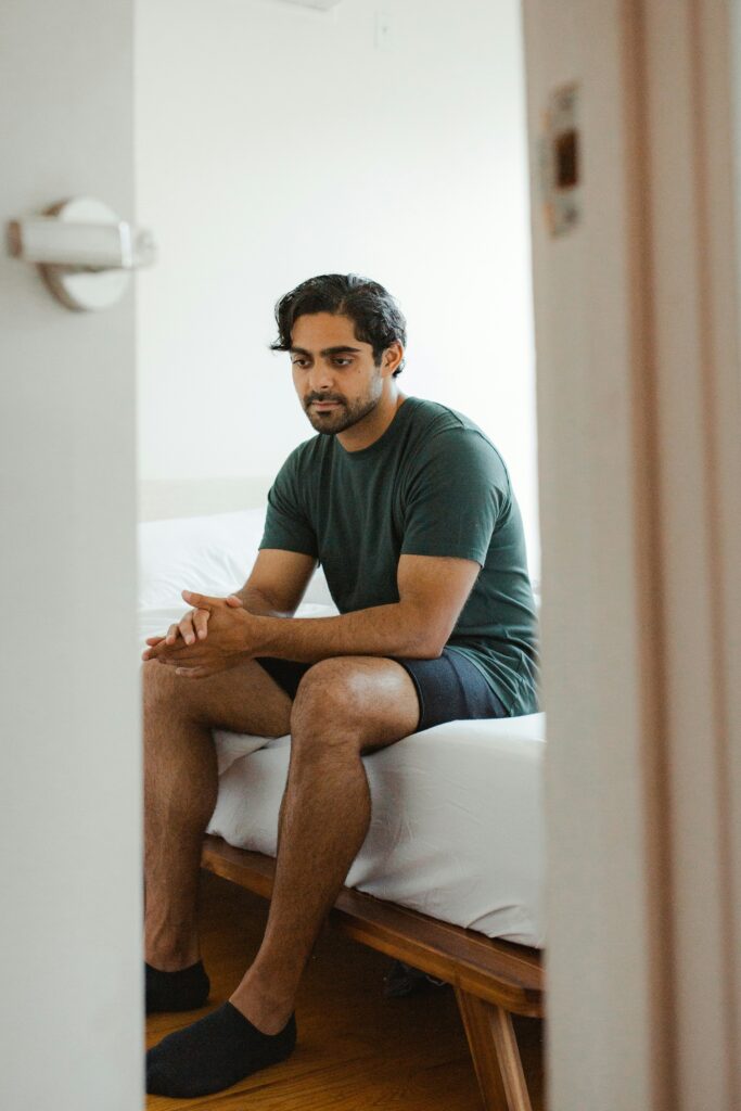 A man sitting alone and reflecting on his mental health. Anxiety therapy for men provides a supportive space to explore and manage emotional well-being.