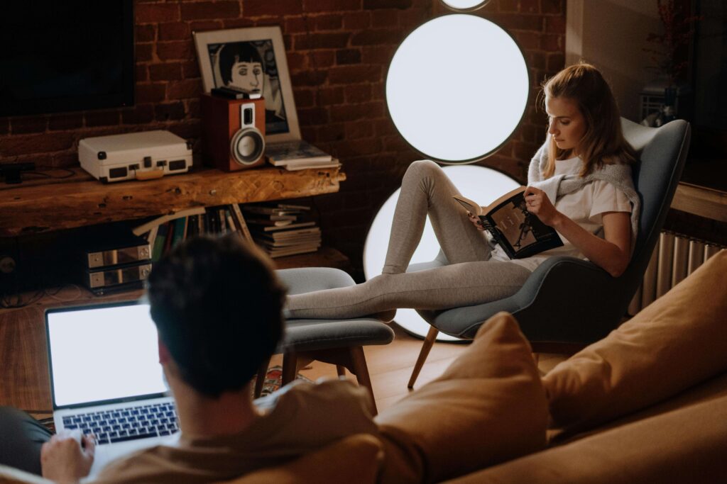 Emotional Disconnection at Home - couples therapist san diego ca - couples therapy san diego ca - couples therapy for conflict san diego ca - mission valley - la - san francisco - california Distant couple sitting separately while using electronics, representing challenges addressed with a couples therapist in San Diego, CA.