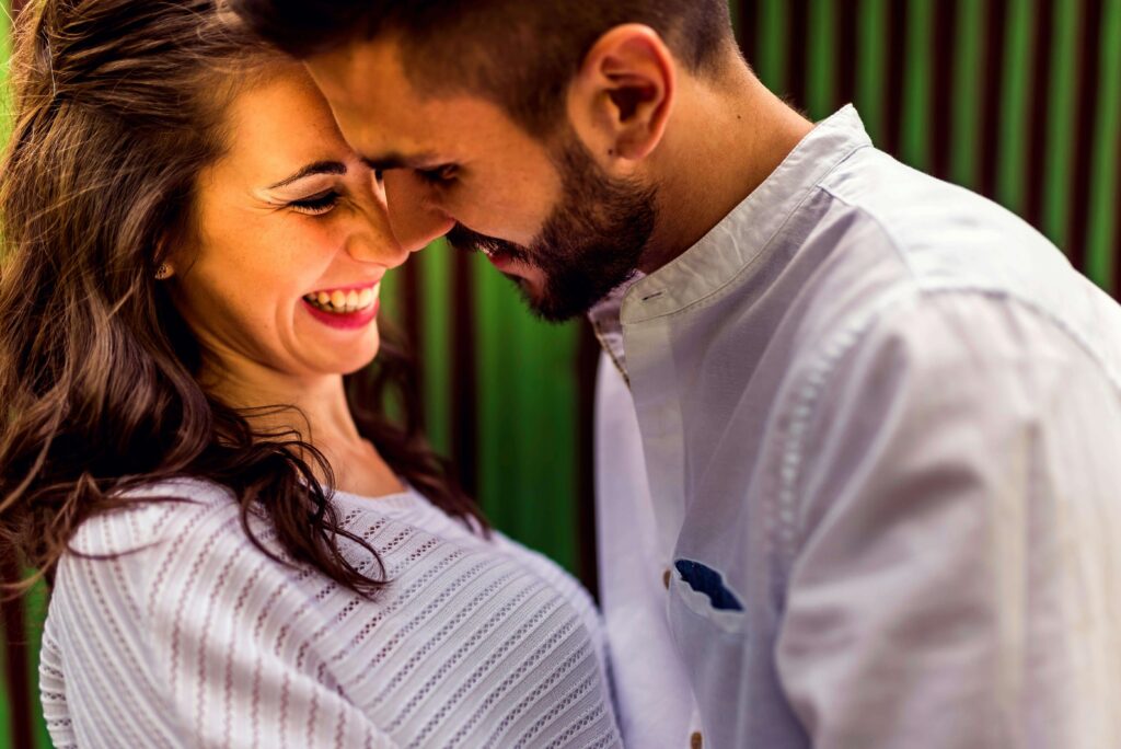 Close-up of a couple smiling in a warm embrace, symbolizing empathy and closeness fostered through San Diego couples therapy.
