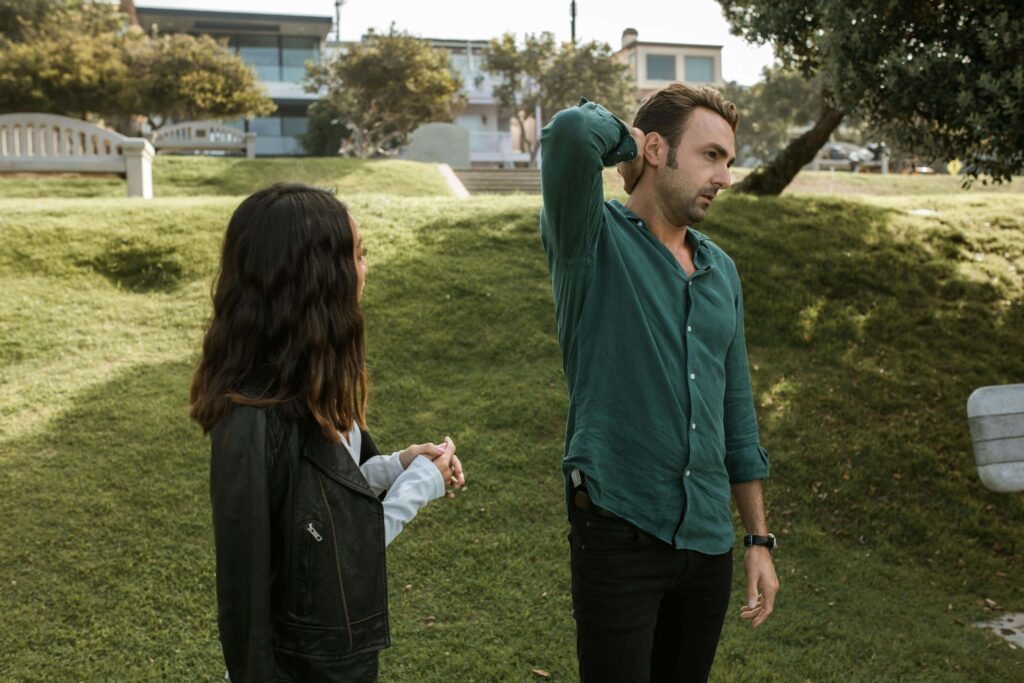 Couple talking while the man appears uncomfortable as the woman speaks, representing defensiveness and emotional tension addressed in couples therapy for defensiveness in San Diego, CA.