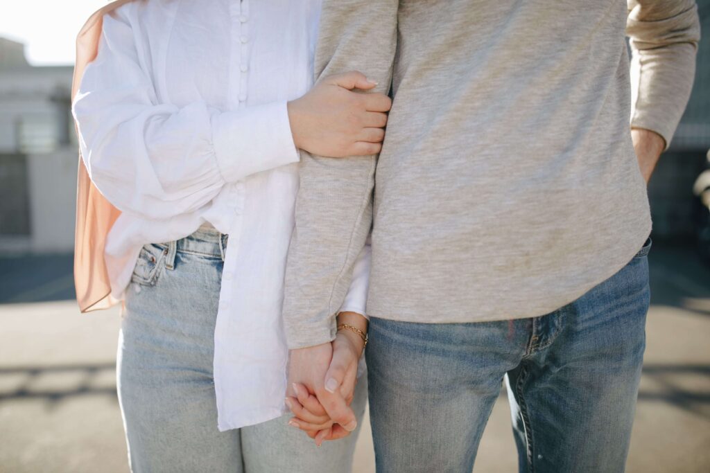 Close-up of a woman holding her partner’s arm, representing reassurance, connection, and emotional support developed through couples counseling in San Diego, CA.