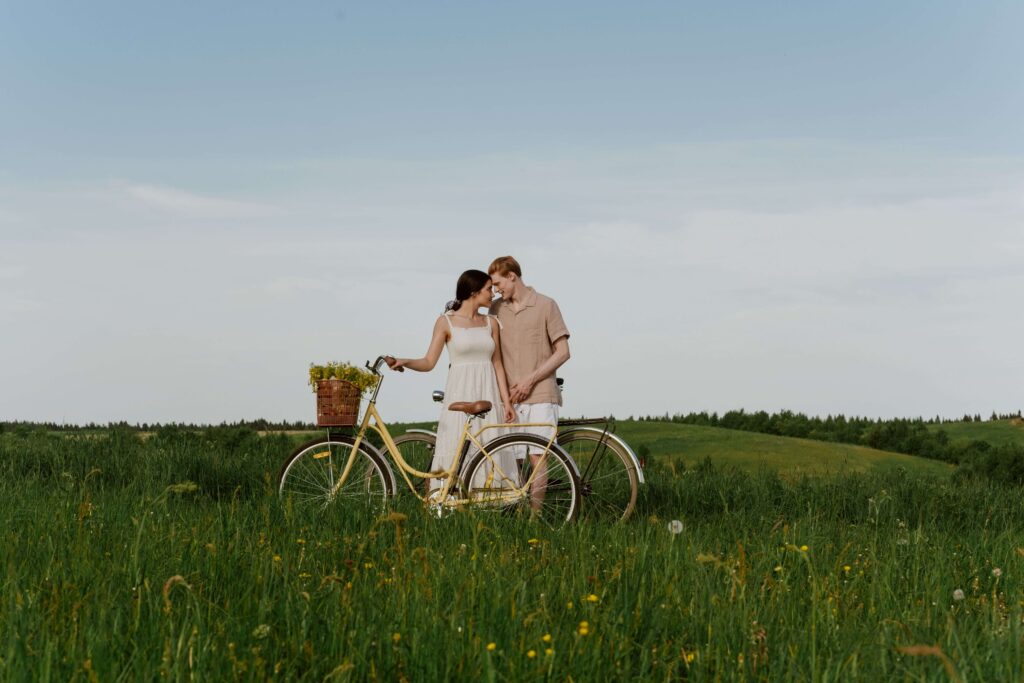 Happy couple standing in a field beside a bicycle, symbolizing trust, authenticity, and deeper connection fostered through relationship counseling in San Diego, CA.
