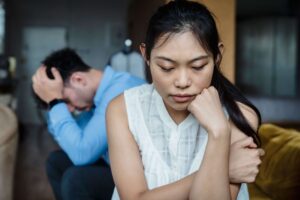 Close-up of a couple looking stressed, with the woman looking down thoughtfully, representing concerns explored in relationship counseling in San Diego, CA.