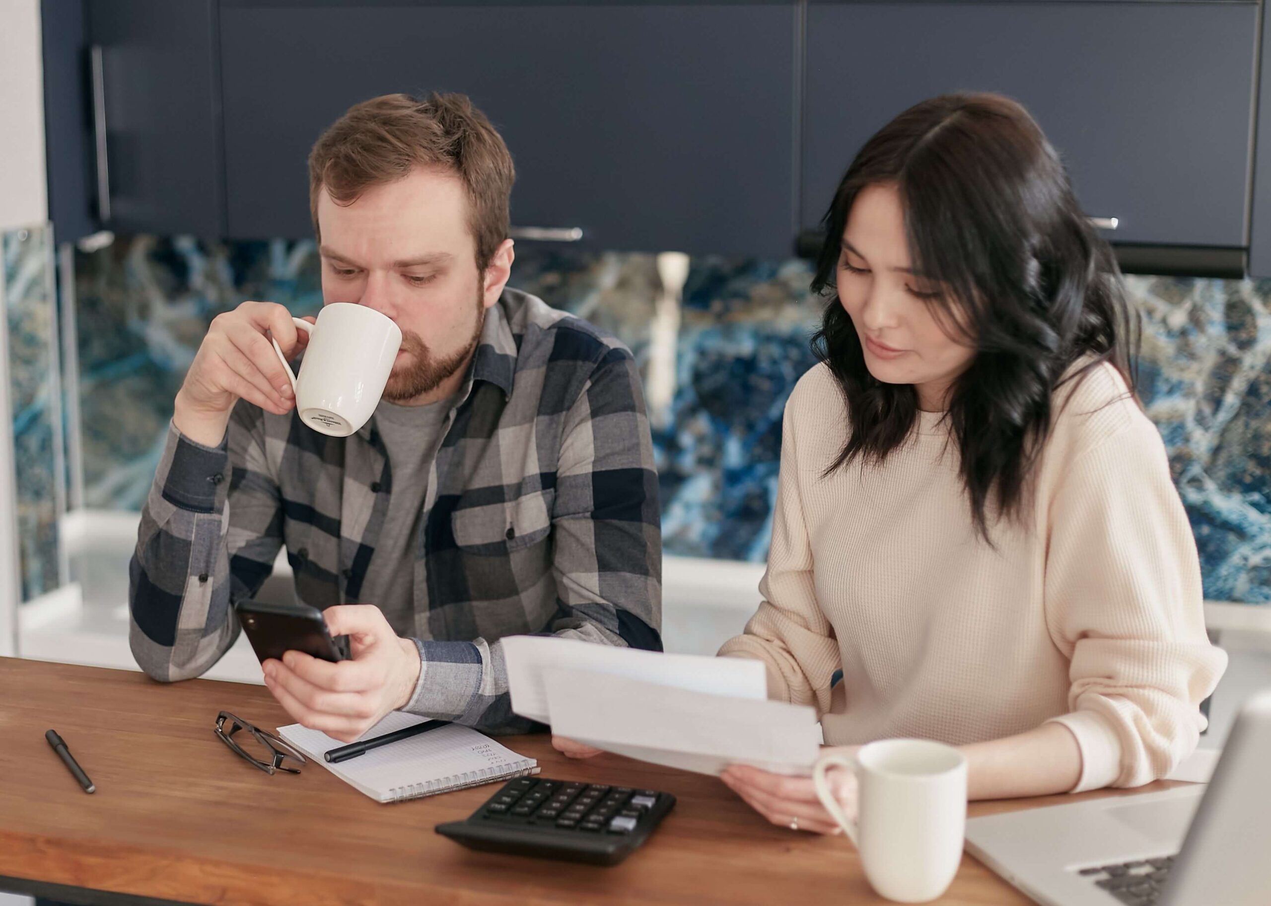 Couple reviewing bills together, illustrating the practical pressures and communication challenges explored in marriage counseling in San Diego, CA.