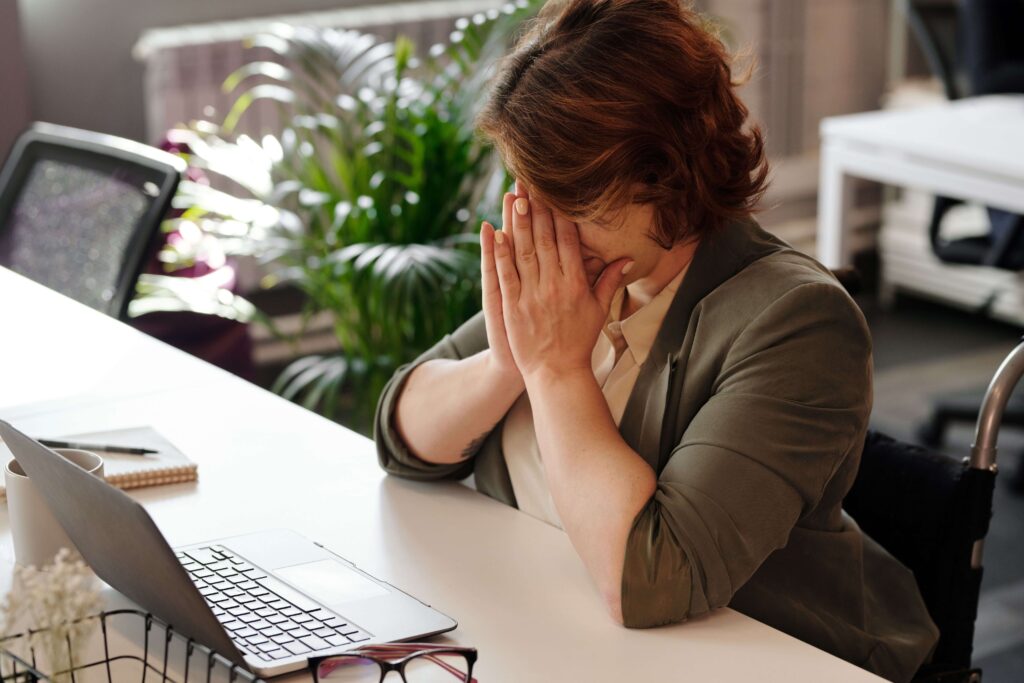 Woman appearing stressed while working, representing the impact of career pressure on emotional well-being and relationships addressed through couples therapy in San Diego, CA.