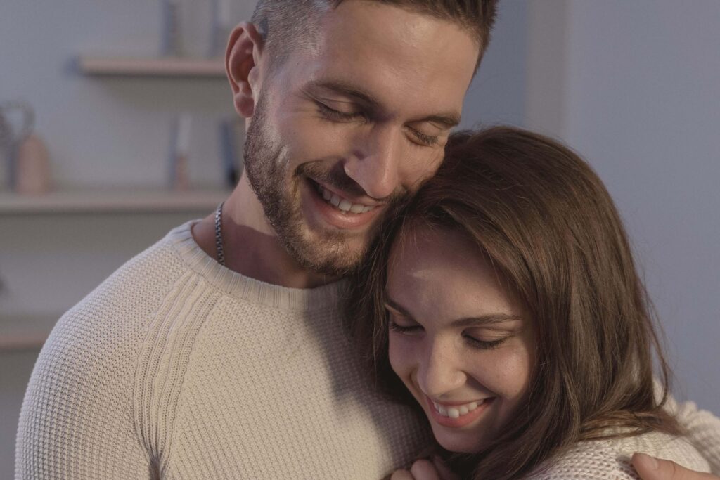 Smiling couple embracing, representing healthy attachment, intimacy, and stronger connection supported through couples therapy in San Diego, CA.