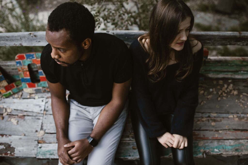 Emotional Distance - relationship counseling san diego - san diego couples therapy - relationship therapist san diego - mission valley - la - san francisco - california Distant couple sitting apart, illustrating disconnection and unresolved communication challenges addressed through relationship counseling in San Diego, CA.
